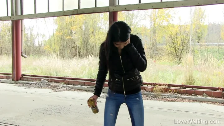Latina teen barefoot in water, covering face, holding can in abandoned