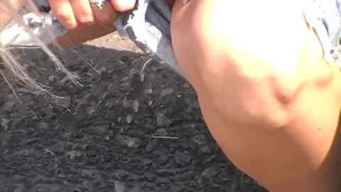 Blonde rips clothes in industrial outdoor strip