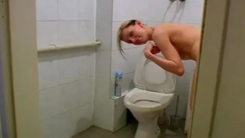 Blonde in a bun pees on toilet, guy cums on floor in POV