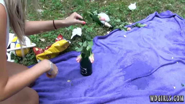 Blonde and dark-haired girl outdoor squirting with flowers and champag