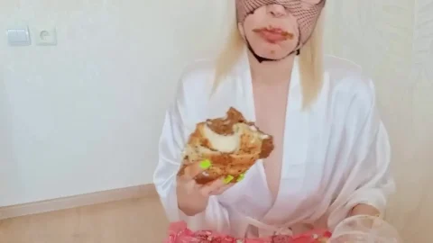 Blonde in fishnet mask eats dessert in white robe