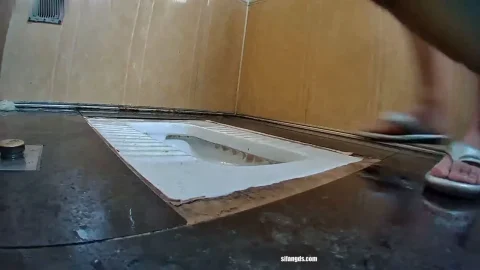 Caucasian Woman in Diaper and Socks Plays with Hole in Bathroom Floor