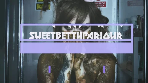 Brunette with tattoos covered in mud, topless in shower