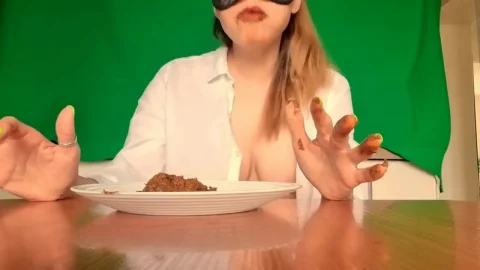 Blonde in black mask eats meat with hands, green nails, kitchen