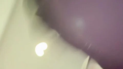 Asian Woman Ties Shoes, Uses Phone Indoors