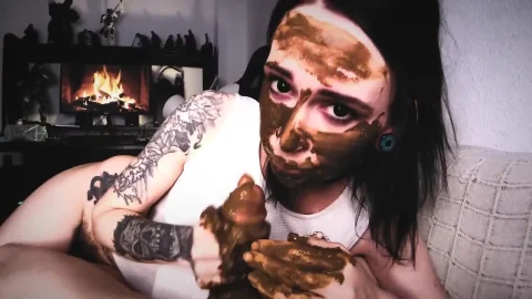 Black-haired brunette with arm tattoos gives fake blowjob on couch